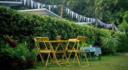 two chairs and a table in a yard with flags at CoZy House Chiangrai in Chiang Rai