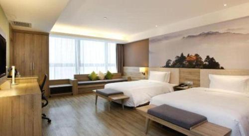 a hotel room with two beds and a television at Atour Hotel Xi'an High Tech Dazhai Road in Xi'an