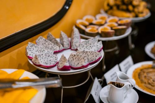 a table with plates of pastries and desserts on plates at Gardenia Hue Hotel in Hue