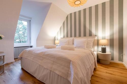 a bedroom with a large bed with a striped wall at Vertical Suite in Zürich