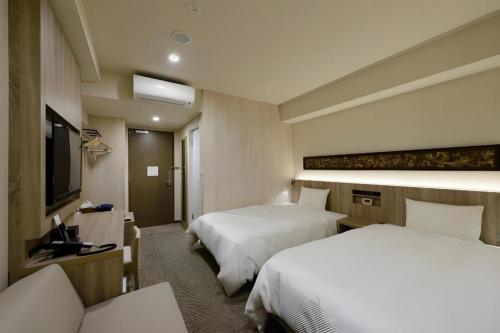 a hotel room with two beds and a television at Hotel IL FIORE Kasai in Tokyo