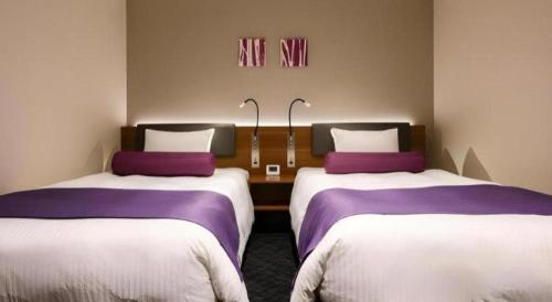 two beds in a room with purple and white sheets at KEIKYU EX INN Haneda Innovation City 2 minutes walk from HICity Exit of Tenkubashi Station in Tokyo
