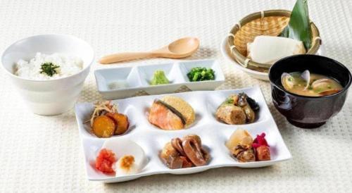 a table with a plate of food and a bowl of rice at KEIKYU EX INN Haneda Innovation City 2 minutes walk from HICity Exit of Tenkubashi Station in Tokyo