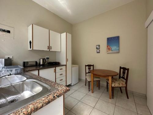 eine Küche mit Spüle und Tisch mit Stühlen in der Unterkunft Douglas Cottage in Pennington