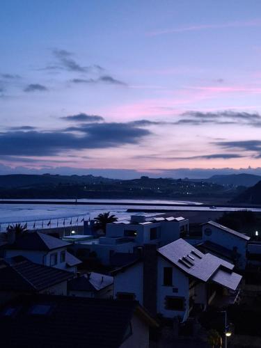 a view of a city and a river at dusk at Doña Carmen Playa Boutique in Suances