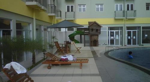 a building with a pool and a playground with a slide at OYO Living 3091 Apt The Suites Metro By Ananda in Bandung
