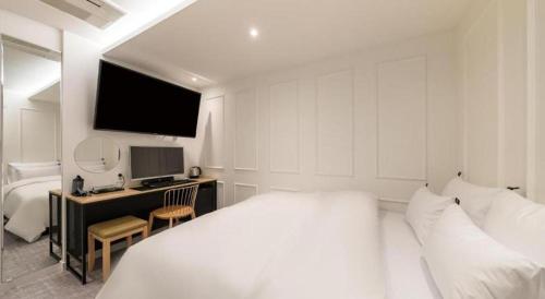a bedroom with a bed and a desk with a computer at Crossing Hotel in Seoul