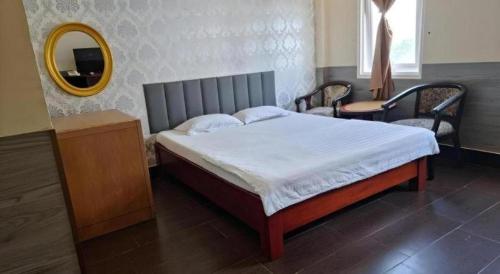 a bedroom with a large bed with a mirror and a mirror at RUBY HOTEL in Cà Mau