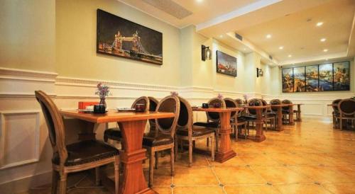 a dining room with tables and chairs and paintings on the wall at London Hotel in Macau