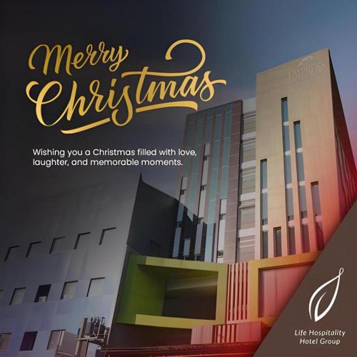 a sign that says merry christmas in front of a building at Life Hotel Soekarno Hatta Makassar in Makassar