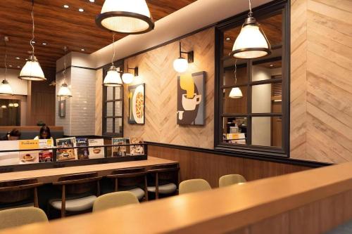 a restaurant with a bar and chairs and lights at KEIKYU EX INN Tokyo Nihombashi in Tokyo