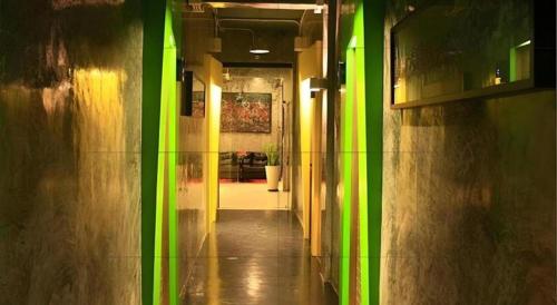 an empty hallway with green walls and a hallway with a hallwayngth at The B Ranong Trend Hotel in Ranong