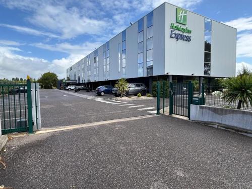 a building with a car parked in a parking lot at Holiday Inn Express - Arcachon - La Teste by IHG in La Teste-de-Buch