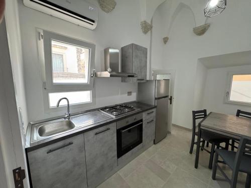 a kitchen with a sink and a stove and a table at A & F di Andrea in Galatina