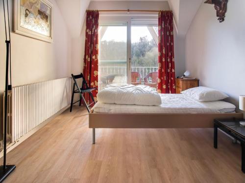 a bedroom with a bed with red curtains and a window at Luxury Pool Villa in Sosoye in Sosoye