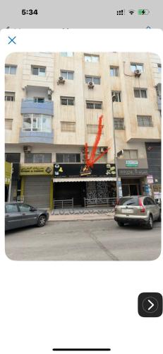 a tall building with cars parked in front of it at Perfect stay in Agadir