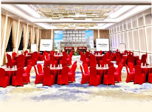 a large room with red chairs and tables in it at All Nite and Day Hotel Alam Sutera in Serpong