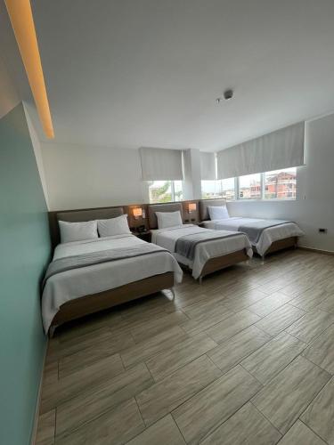 a bedroom with three beds in a room at Hotel Puerto Pacifico Guayaquil Airport in Guayaquil