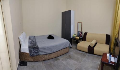 a small bedroom with a bed and a chair at Entire studio apartment near Al ain mall in Al Ain