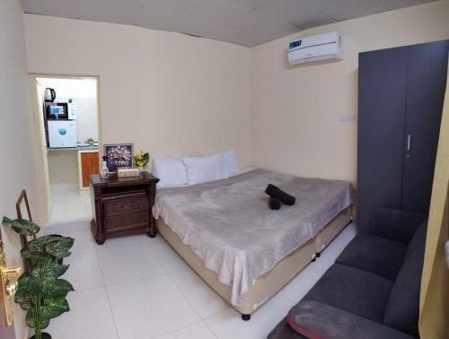 a bedroom with a bed and a table and a couch at Entire studio apartment near Al ain mall in Al Ain