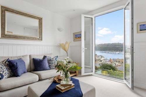 a living room with a couch and a large window at Kittiwake - Outstanding River Views in Dartmouth