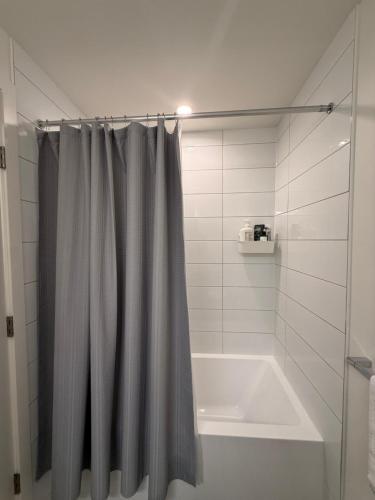 a bathroom with a shower curtain and a bath tub at Victoria Colwood Place in Colwood