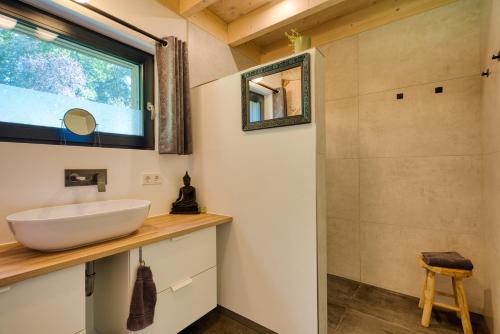a bathroom with a sink and a shower at Wäller Haus - Modern villa with fireplace & large natural garden in Breitscheid