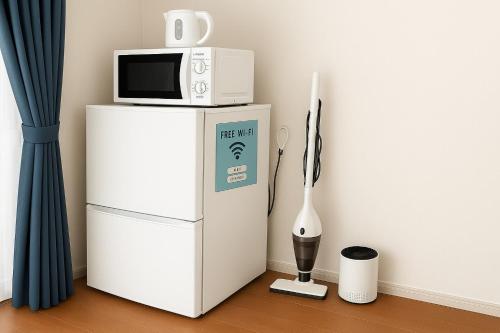a microwave sitting on top of a refrigerator at Highness Gojo - Vacation STAY 18191 in Dazaifu