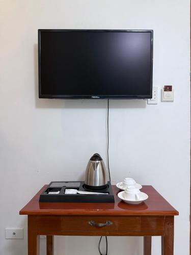 a wooden table with a television on top of it at Isabelle Hotel in Puerto Princesa City
