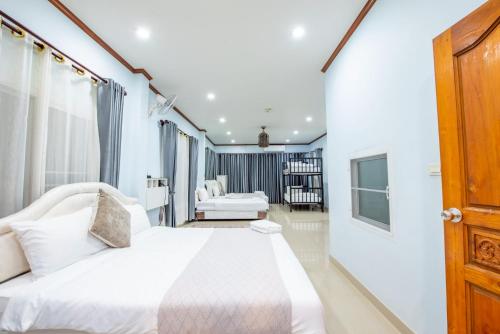 a bedroom with a large white bed in a room at White Sand Pool Villa Pattaya in Jomtien Beach