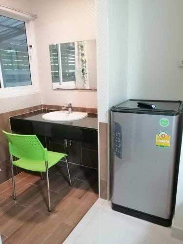 a kitchen with a green chair and a sink at KS RESIDENCE Victory Monument in Bangkok