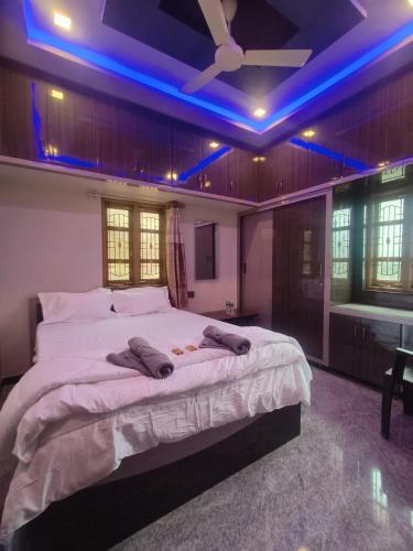 a bedroom with a large bed with blue lights on it at Amrutha Homestay in New Hampi