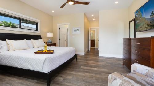 a bedroom with a large bed and a dresser at ISLAND SEABATICAL Restful 3BR Ainamalu Home with Private Pool in Waikoloa