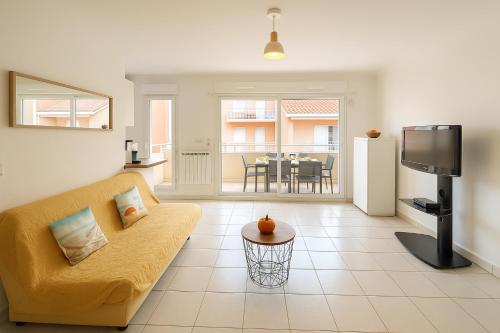 sala de estar con sofá amarillo y TV en Olivéa, en Antibes
