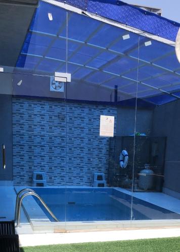 a swimming pool with a glass wall around it at فلل ومسابح بلوسكاي الباحه-العقيق فله من ثلاث غرف نوم in Al ‘Aqīq