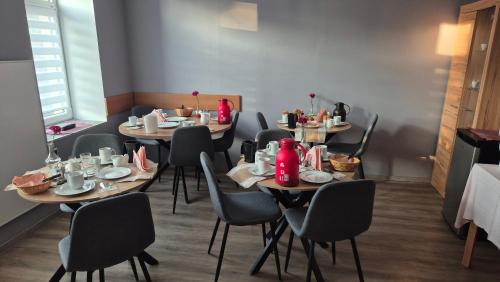 a dining room with tables and chairs with food at Pension STELLA in Lutherstadt Eisleben