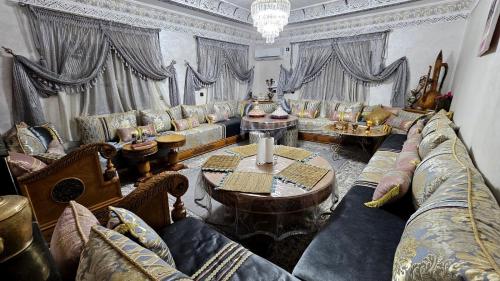 un grand salon avec des canapés, des tables et des rideaux dans l'établissement Château Berbère Madame DELLAL, à Taroudant