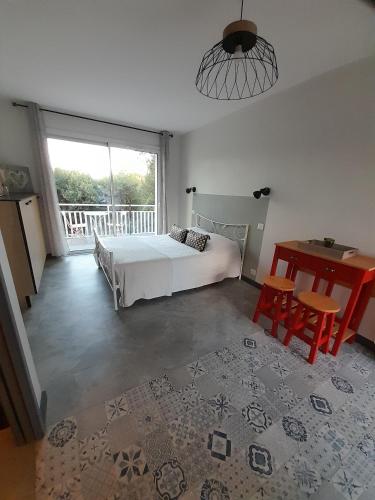 a bedroom with a bed and a table and a window at Chabas Studio in Lagarrigue