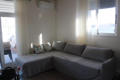 a couch in a living room with a window at TopView Apartment In front of Saranda Port in Sarandë