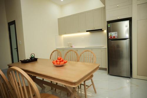 a kitchen with a table with a bowl of fruit on it at M&M homestay vincom Quang Tri in Quang Tri