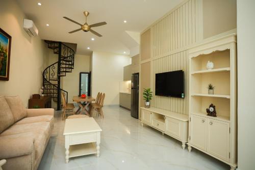 a living room with a couch and a flat screen tv at M&M homestay vincom Quang Tri in Quang Tri