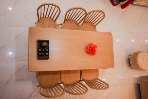 a wooden table with four chairs and a remote control at M&M homestay vincom Quang Tri in Quang Tri