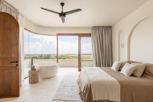 una camera da letto con un letto grande e una vasca da bagno di Villa Zyloh Sunset - New, Luxury, Ocean View Villa, Bingin a Uluwatu