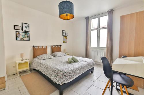 a bedroom with a bed and a desk and a window at Le Solençon de 1 à 4 personne Hypercentre in Cognac