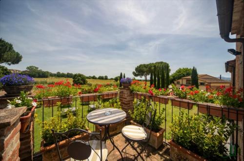 a patio with tables and chairs in a garden at Podere La Ceppa1 in Sinalunga