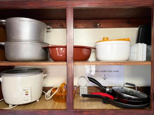 a shelf with pots and pans and other kitchen utensils at Fare Bungalow in Papeete