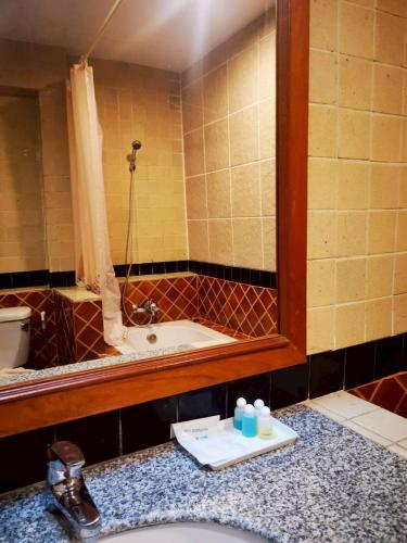 a bathroom with a sink and a mirror and a tub at Lifeup care and hotel in Ban Mai