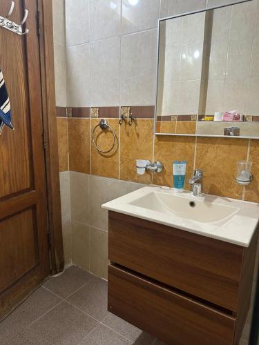 un baño con lavabo y espejo en 3 Bedroom Family Apartment in Amman, en Amán