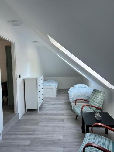 a attic room with two beds and a staircase at Apartman Bojnice Kúpele in Bojnice