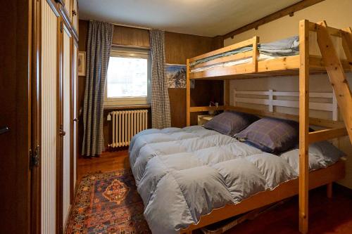 a bedroom with two bunk beds and a window at Casa Elena in Breuil-Cervinia